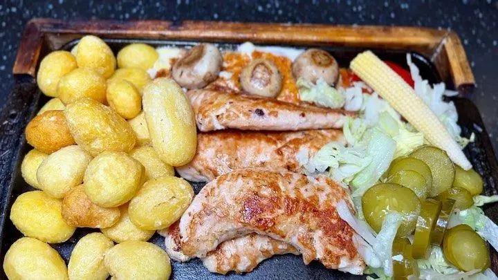 کافه رستوران هریک: بشقاب ویژه مرغ گریل شده با سیب زمینی تنوری، قارچ، ذرت و مخلفات تازه. یک تجربه غذایی کامل و لذیذ.