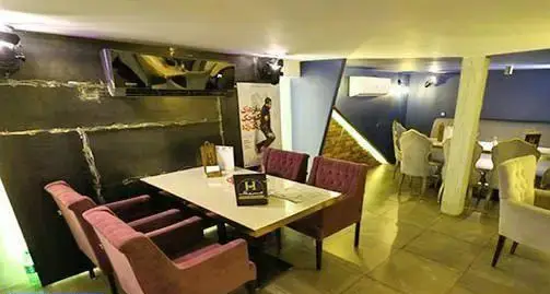 فضای داخلی دنج و مدرن کافه رستوران هریک با چیدمان زیبای میز و صندلی‌ها و دکوراسیون شیک، مناسب اوقات فراغت و دورهمی.