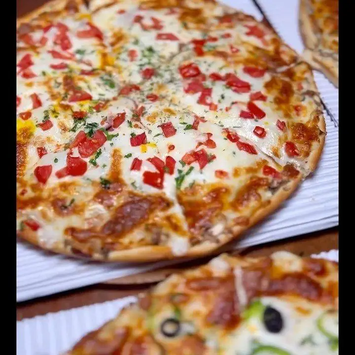 پیتزا گوجه و پنیر مجلل و خوش‌طعم در کافه رستوران هریک، انتخابی عالی از منوی غذای ما برای یک تجربه لذت‌بخش و بی‌نظیر.