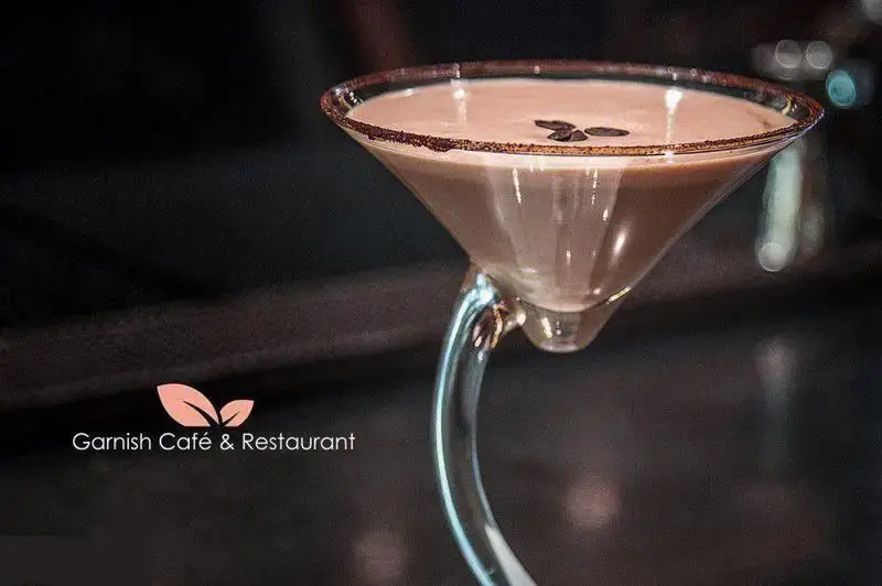 نوشیدنی شکلاتی کوکتل در لیوان مارتینی خاص کافه رستوران گارنیش با لبه شکلاتی و دانه های قهوه، تجربه‌ای دلپذیر.