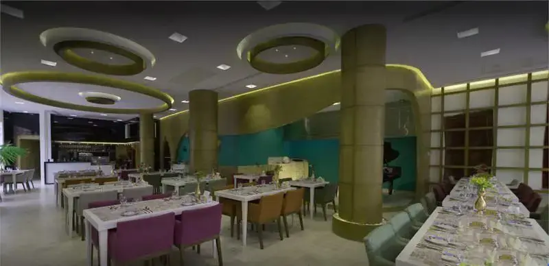 تصویری از فضای داخلی کافه رستوران گارنیش، با دکوراسیون شیک، میز و صندلی‌های متنوع، نورپردازی مدرن و طراحی منحصر به فرد برای مشتریان.