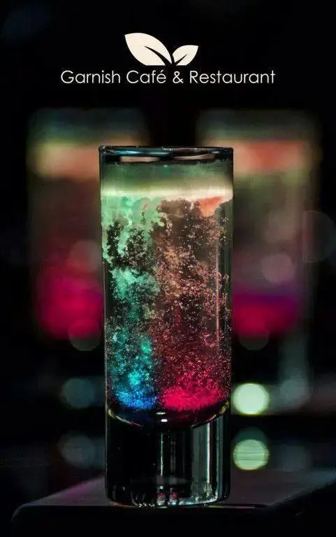 کوکتل رنگی و چشم‌نواز کافه رستوران گارنیش با حباب‌های درخشان، نمادی از محیط دنج و تجربه لذت‌بخش.