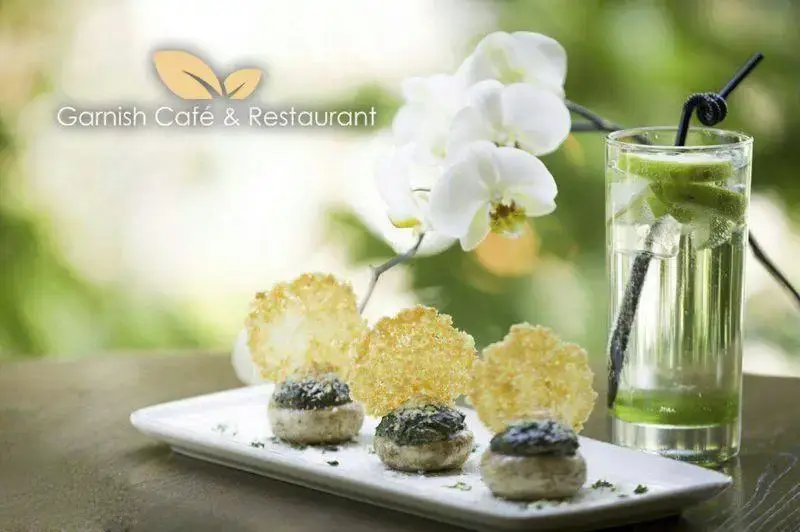 غذایی اشتهابرانگیز و نوشیدنی تازه در کافه رستوران گارنیش: قارچ شکم پر و کریسپ پنیر با ارکیده‌های سفید زیبا.