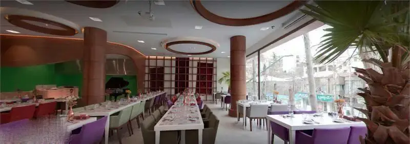 تصویری از فضای داخلی بزرگ و دلباز کافه رستوران گارنیش، دارای دکوراسیون مدرن، میزهای چیده شده، پیانو و نورگیر عالی.