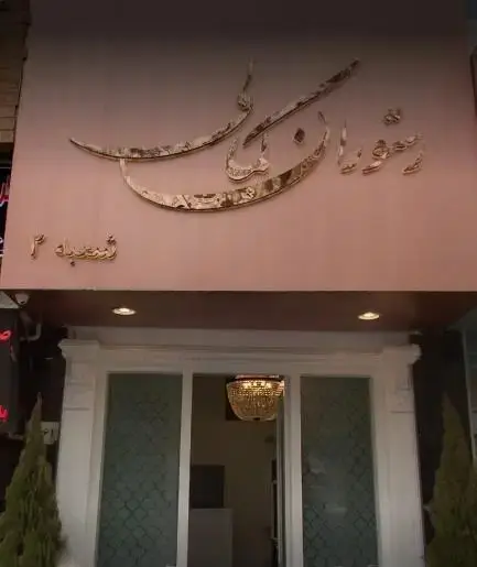 نمای بیرونی کافه رستوران گارنیش شعبه ۲، شامل تابلوی نفیس طلایی با خط نستعلیق و ورودی با درب‌های شیشه‌ای و آویز لوستر زیبا.