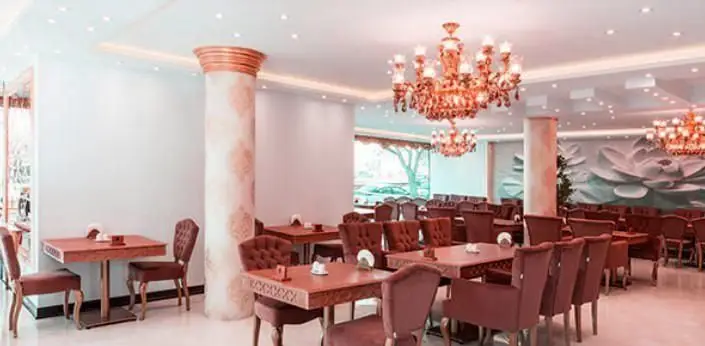 نمای دنج و لوکس فضای داخلی رستوران سعادت، مجهز به میز و صندلی‌های شیک، لوسترهای درخشان و دکوراسیون چشم‌نواز برای تجربه‌ای دلنشین.