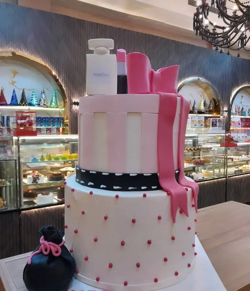 کیک تولد سفارشی سه طبقه صورتی و سفید با تم لوازم آرایش و جواهرات، نمونه ای از هنر قنادی شیرینی الف شعبه تهرانپارس.