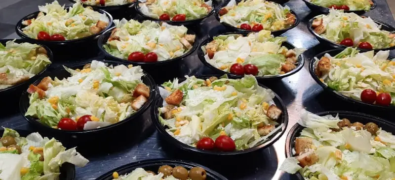 سفارش انبوه سالادهای سزار تازه و سالم از "پیتزا سرخاب سیب" با کاهو، کروتون، ذرت، گوجه گیلاسی و زیتون. مناسب برای کترینگ و تحویل.