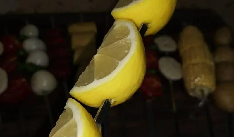 لیموهای تازه و معطر روی سیخ، آماده برای سرو کنار کباب‌های داغ جگرسرای گلشن. انتخابی عالی برای طعم‌دار کردن جگر و انواع کباب.