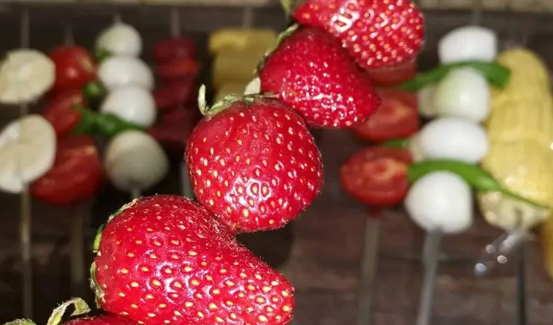 توت‌فرنگی‌های رسیده و تازه در کنار سیخ‌های متنوع از مواد اولیه مرغوب و رنگارنگ جگرسرای گلشن، تجربه‌ای از طعم اصیل.