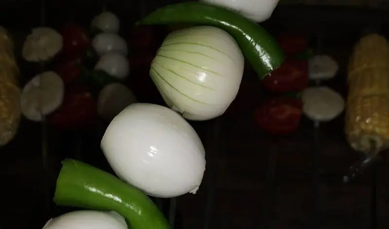 مواد اولیه تازه و باکیفیت کباب جگرسرای گلشن شامل پیاز سفید، فلفل سبز، گوجه فرنگی و بلال، آماده برای سیخ زدن.
