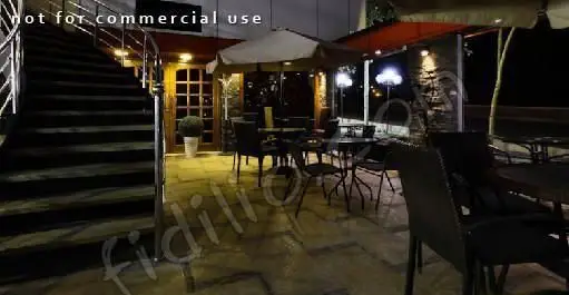 تصویری از فضای باز و زیبای کافه فلورانس در شب، با نورپردازی دلنشین، پله‌های ورودی و میز و صندلی‌های چیده شده برای گذراندن اوقاتی خوش.