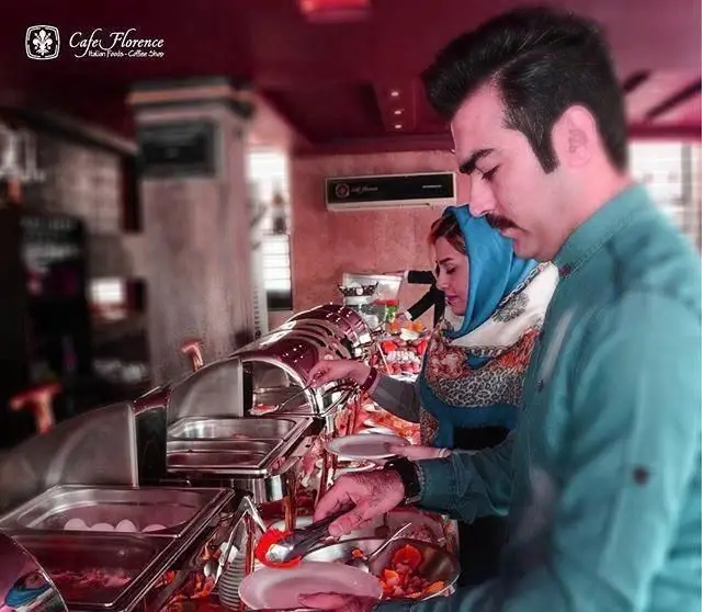 مشتریان کافه فلورانس در حال انتخاب غذا از میز بوفه صبحانه کامل. تجربه‌ای دلنشین از سلف سرویس در محیطی گرم و دعوت‌کننده.