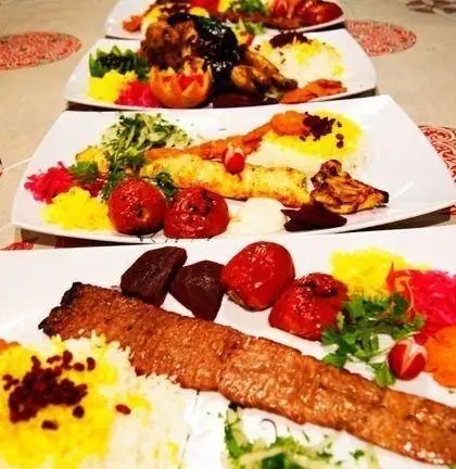 سینی‌های رنگین انواع کباب ایرانی شامل کوبیده، جوجه، چلو زعفرانی و مخلفات در سفره‌خانه سنتی انارستان.