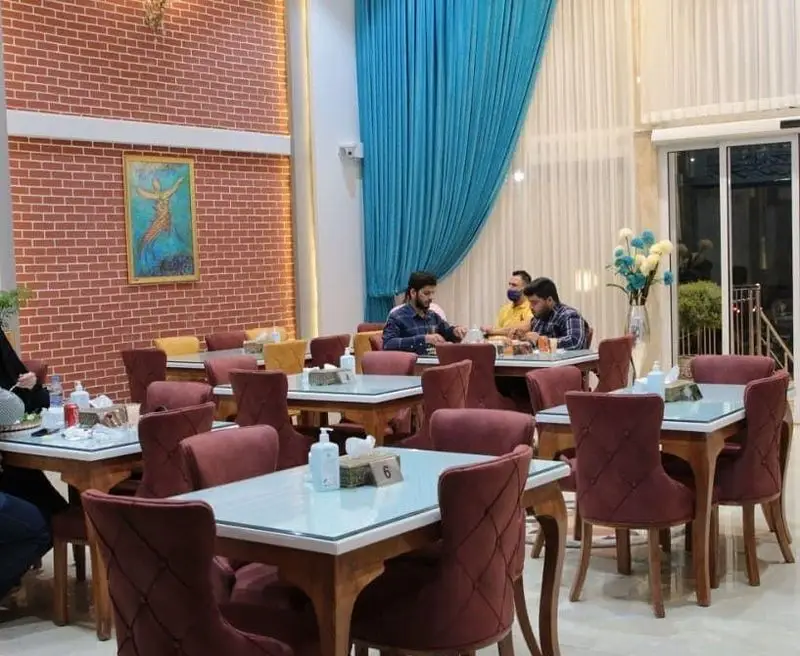 نمایی از فضای داخلی رستوران درباری ۱۱۰، محیطی زیبا و دنج با دکوراسیون جذاب، میز و صندلی‌های راحت برای مشتریان.