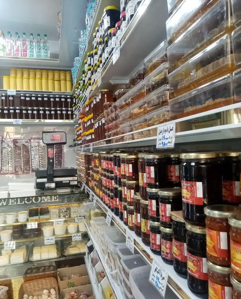 فروشگاه لبنیات سنتی لیقوانی نصر با قفسه‌های پر از عسل طبیعی، انواع مربا، پنیر سنتی و محصولات غذایی تازه و سالم