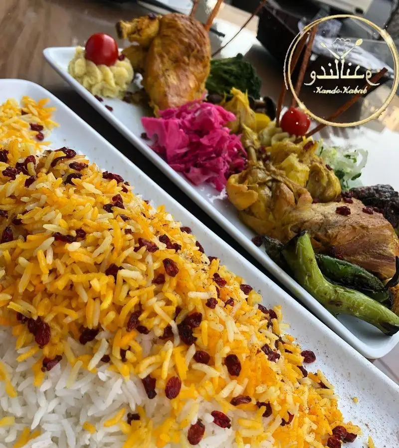 نمای نزدیک از چلو کباب و زرشک پلو با مرغ در رستوران کندو کباب. غذای اصیل ایرانی با کیفیت عالی و سرو جذاب.