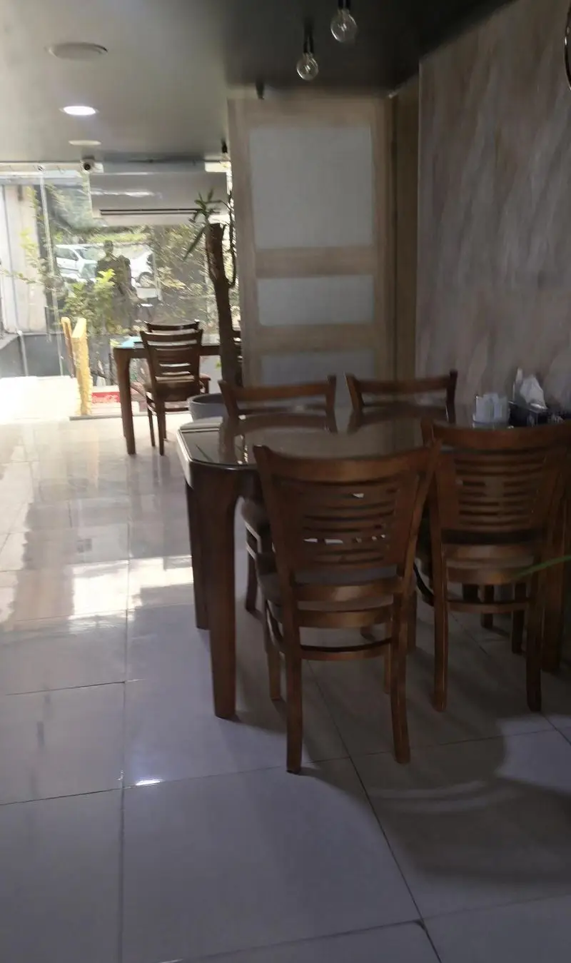 محیط دنج و تمیز رستوران کندو کباب با نورپردازی طبیعی و چیدمان منظم میز و صندلی‌های چوبی، آماده پذیرایی.