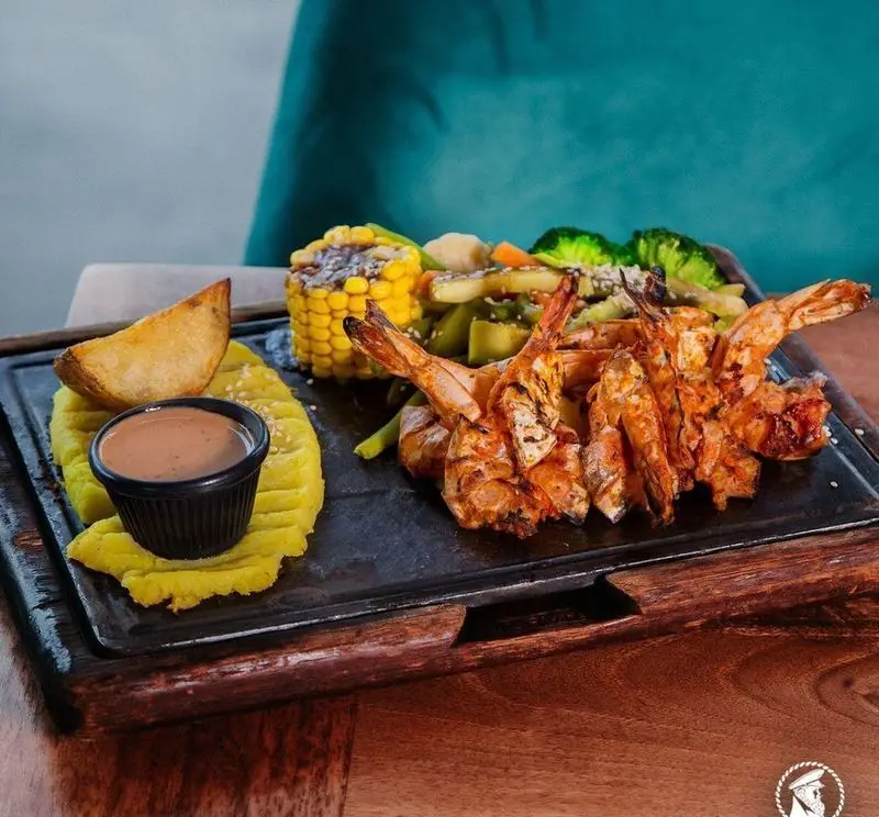 بشقاب غذای دریایی کاپیتان لانژ: میگو گریل، پوره، ذرت، سیب‌زمینی و سبزیجات تازه. مناسب برای شام و ناهار در کافه.