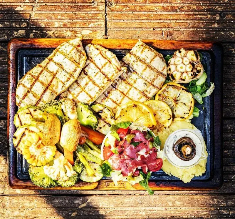 سینه مرغ گریل کاپیتان لانژ همراه با سبزیجات گریل (کدو، ذرت، بروکلی)، سالاد، پوره و سس قارچ. غذایی کامل و مقوی.