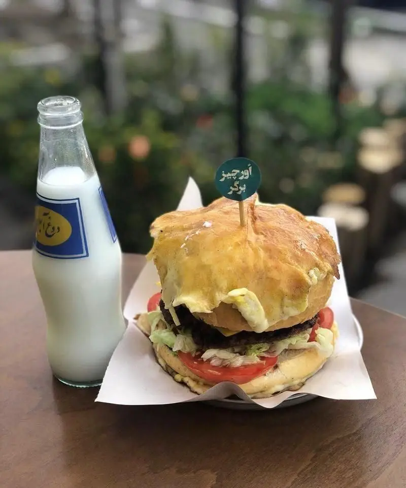 برگر آنتیک برگر: اور چیز برگر لذیذ با نان تازه، گوشت آبدار، کاهو، گوجه و رویه تخم‌مرغ، سرو شده با بطری دوغ و زعفران خنک