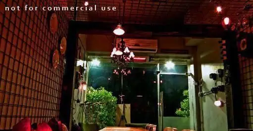 محیط داخلی شبانه و دلپذیر کافه رستوران توپیچ با نورپردازی زیبا، دکوراسیون گرم و فضای دنج برای دورهمی‌های دوستانه.