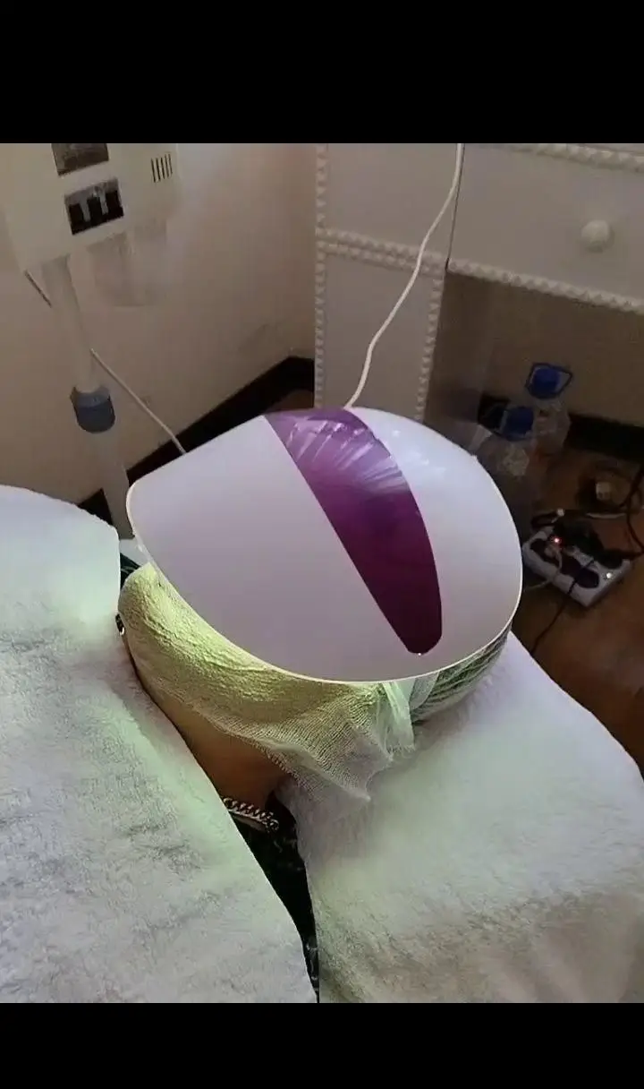 دستگاه نوردرمانی و ماسک ال ای دی صورت در حال استفاده برای پاکسازی و جوانسازی پوست مشتری در سالن زیبایی ساناز صفری
