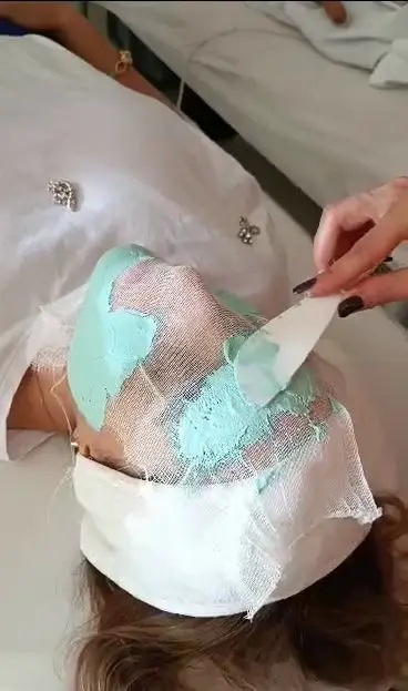 مشتری در حال دریافت فیشیال و ماسک صورت ترمیمی در سالن زیبایی ساناز صفری برای پاکسازی عمیق و جوانسازی پوست.