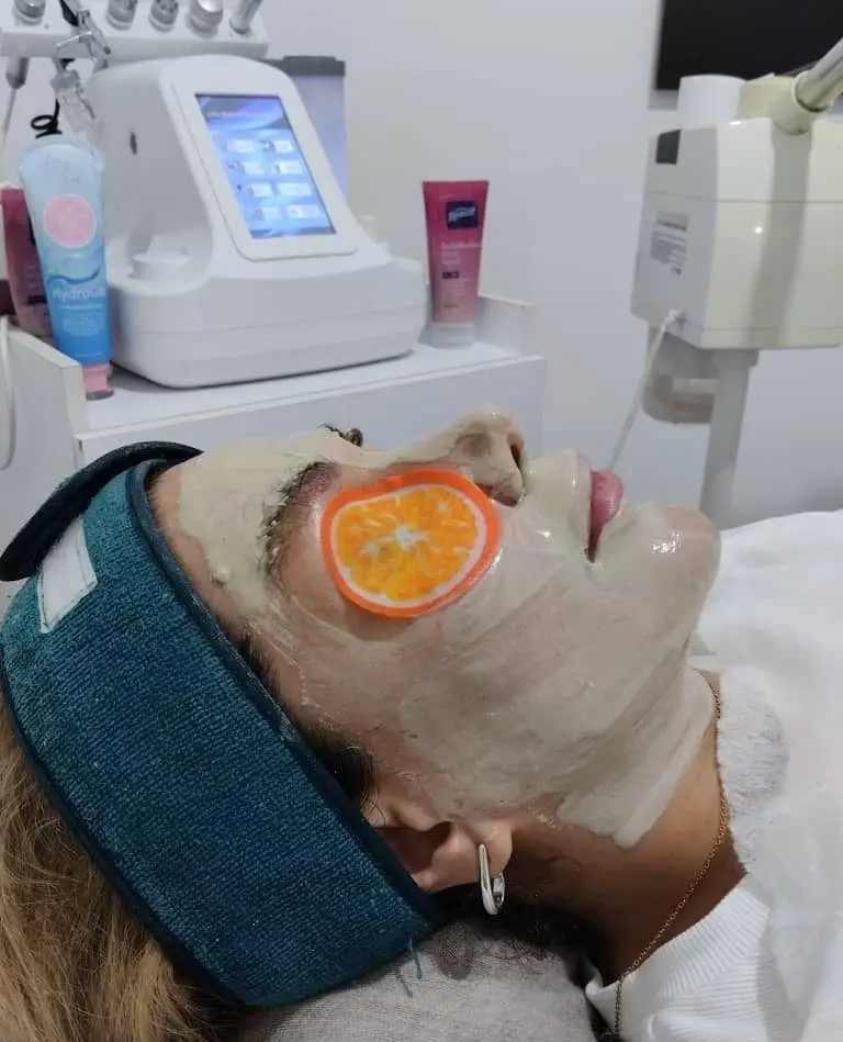 مراحل پاکسازی تخصصی پوست و گذاشتن ماسک صورت به همراه پد پرتقالی روی چشم در بخش فیشیال سالن زیبایی ساناز صفری با دستگاه