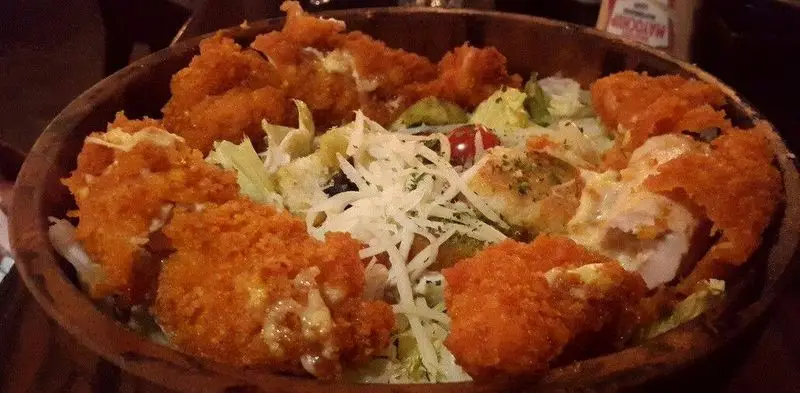 تصویری از سالاد سزار مرغ سوخاری رستوران میخوش با تکه‌های کریسپی مرغ، کاهو تازه، پنیر و گوجه. غذایی لذیذ و دلنشین.