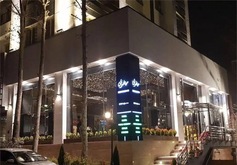 نمای بیرونی شیک رستوران میخوش در شب، با نورپردازی زیبا، پنجره‌های بزرگ و فضای دلنشین. مناسب برای جستجوهای رستوران.