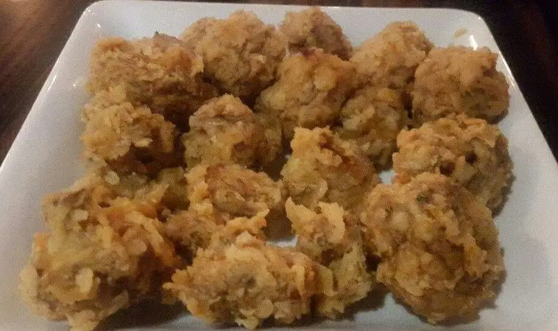 نمایی نزدیک از بشقاب پر از خوراکی‌های سوخاری و ترد رستوران میخوش، با رنگ طلایی جذاب و بافت کریسپی عالی، یک گزینه خوشمزه.