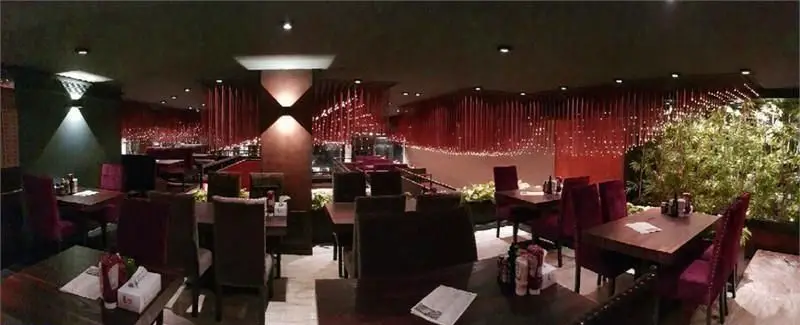 نمای پانوراما از فضای داخلی رستوران و کافه میخوش با طراحی مدرن، دکوراسیون خاص قرمز رنگ و محیط دلپذیر و مناسب دورهمی.