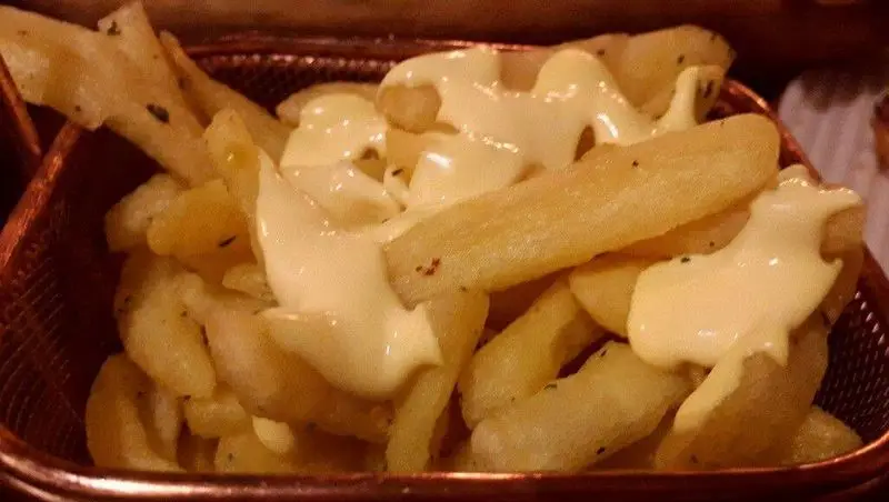 سیب زمینی سرخ کرده لذیذ و طلایی با روکش سس پنیر مخصوص، طعمی بی‌نظیر برای تجربه در فست فود میخوش.