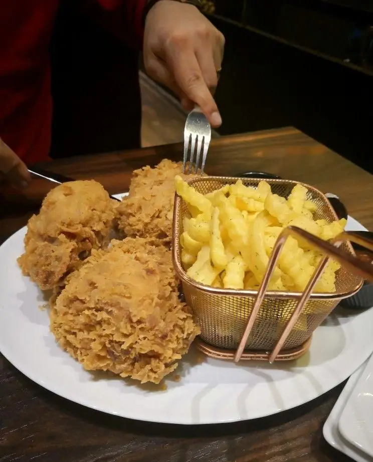 مرغ سوخاری ترد و طلایی میخوش همراه با سیب زمینی سرخ کرده در یک رستوران دنج و دلپذیر. تجربه‌ای خوشمزه از فست فود.