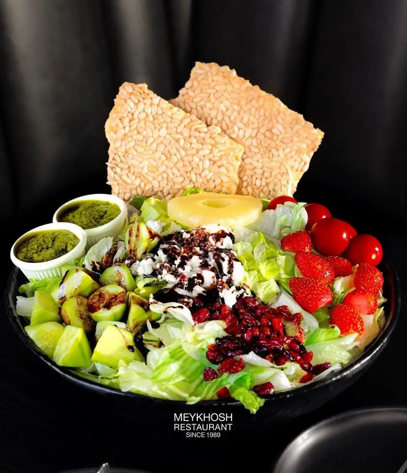 سالاد متنوع و رنگارنگ میخوش شامل میوه و سبزیجات تازه، پنیر، توت فرنگی، آناناس و نان کنجدی در رستوران میخوش.