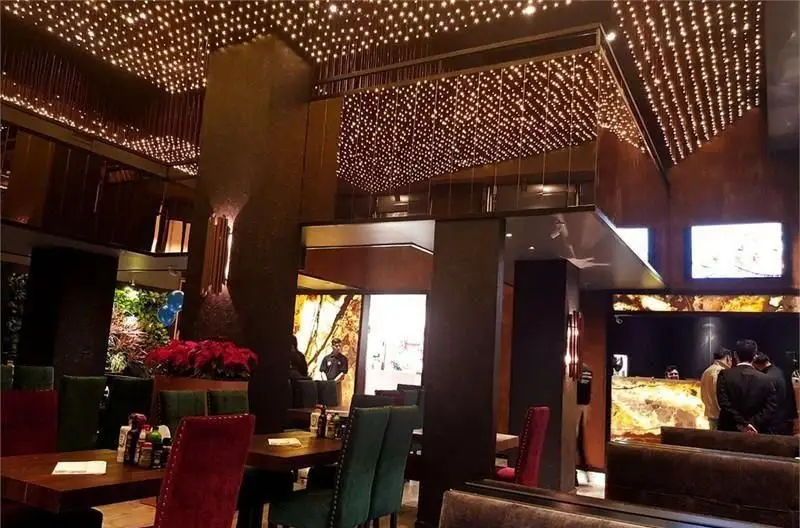 دکوراسیون داخلی لوکس و شیک رستوران میخوش با سقف کهکشانی پرنور، مبلمان مجلل و محیطی دلنشین برای تجربه غذاخوری.