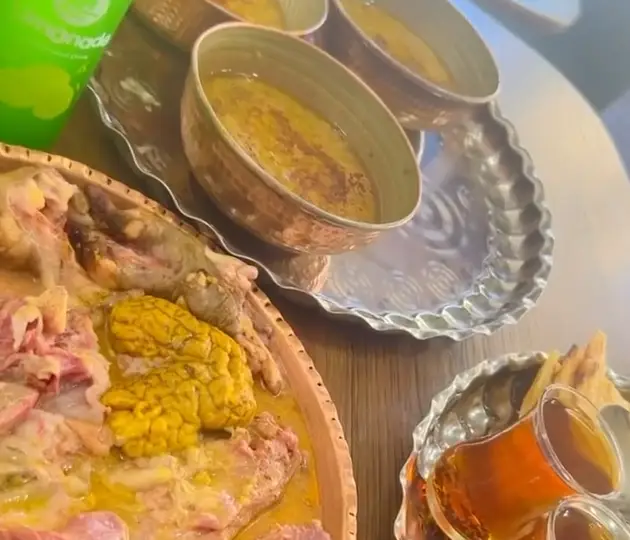 نمایی اشتهاآور از کله پاچه سنتی طباخی توکلی، شامل مغز و گوشت، با آبگوشت داغ و چای، ایده‌آل برای یک صبحانه کامل ایرانی.