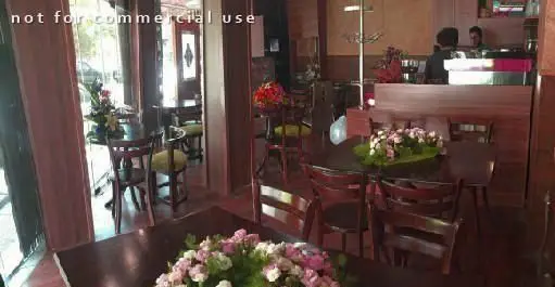 فضای داخلی دلنشین کافه رستوران ملورین با میز و صندلی‌های چوبی، دکوراسیون گرم و گل‌آرایی زیبا برای تجربه‌ای آرامش‌بخش.