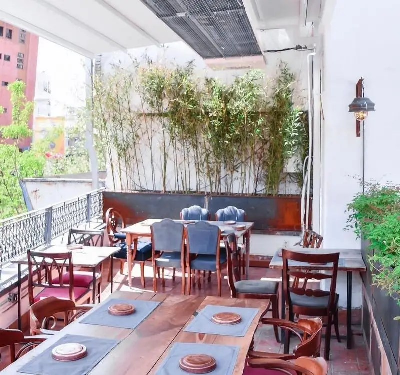 تراس زیبا و دنج رستوران مس توران با چیدمان میز و صندلی‌های شیک، گیاهان بامبو و چشم‌انداز شهری؛ مکانی ایده‌آل برای صرف غذای لذت‌بخش.