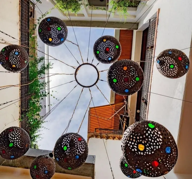 نمایی از دکوراسیون سنتی و زیبای فضای باز رستوران مس توران با فانوس‌های آویز رنگارنگ و طرح‌دار، جلوه‌ای جذاب برای مشتریان.