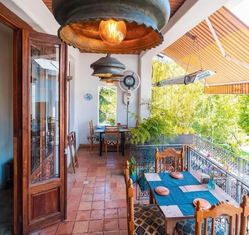 تراس زیبا و دنج رستوران مس توران با چیدمان سنتی، میزهای غذاخوری در فضای باز و منظره سرسبز دلنشین.