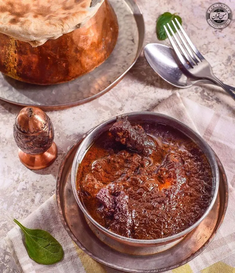 خورش سنتی و نان داغ ایرانی در ظروف مسی زیبا، تجربه‌ای اصیل از غذای خوشمزه رستوران مس توران، طعم بی‌نظیر.