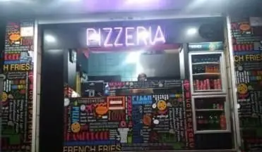 نمای خارجی و دکور جذاب پیتزا برگر فیروزی در شب، با تابلوی نئون پیتزا، منوهای رنگارنگ فست فود شامل برگر و سیب‌زمینی سرخ کرده.