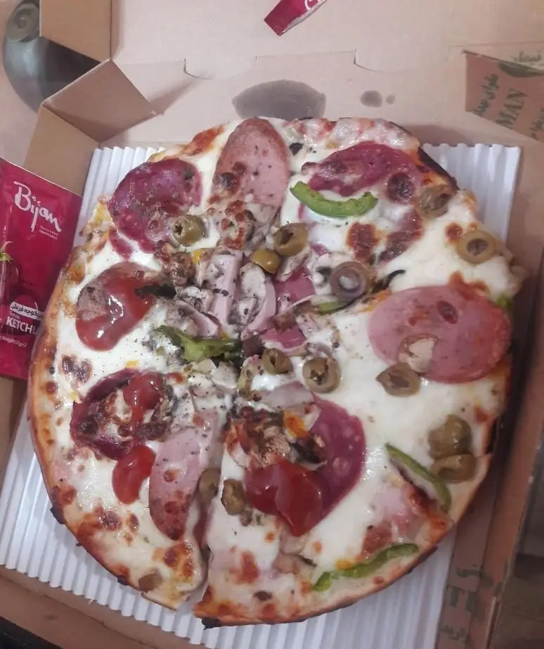 پیتزا برگر فیروزی: پیتزا مخلوط خانوادگی با سس کچاپ بیژن، ژامبون، سالامی، قارچ، زیتون و فلفل دلمه، در جعبه مخصوص آماده تحویل.