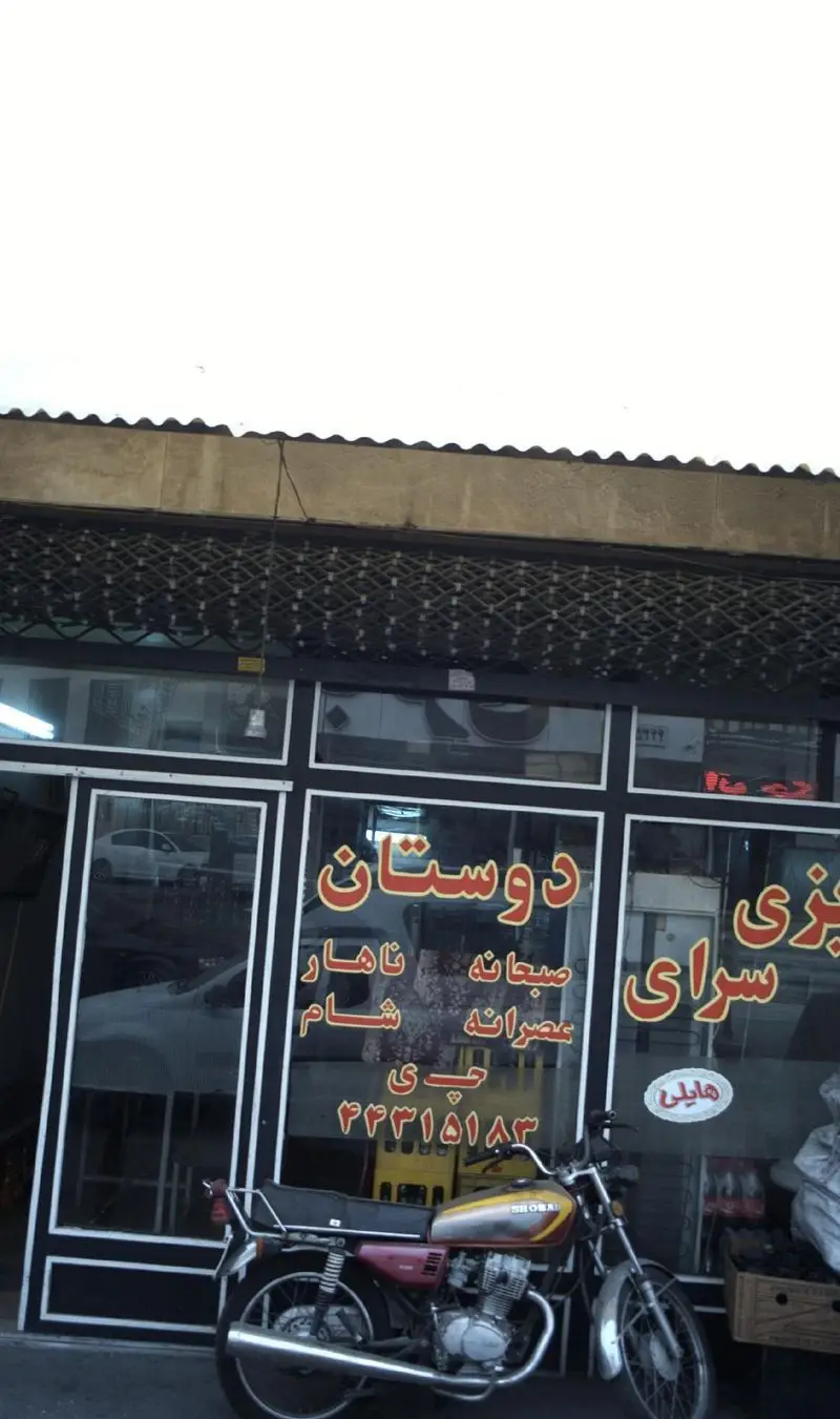 تصویر نمای بیرونی دیزی سرای دوستان با موتورسیکلت در جلوی ویترین، ارائه دهنده صبحانه، ناهار، شام و عصرانه. تلفن: ۴۴۳۱۵۱۸۳