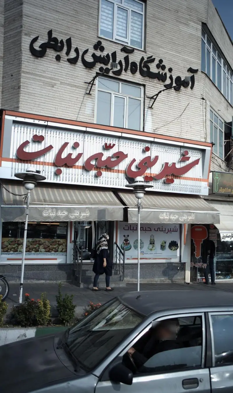 شیرینی حبه نبات، ویترین رنگارنگ انواع کیک، شیرینی و دسر. تابلوی اصلی قنادی و آموزشگاه آرایش رابطی در یک ساختمان.
