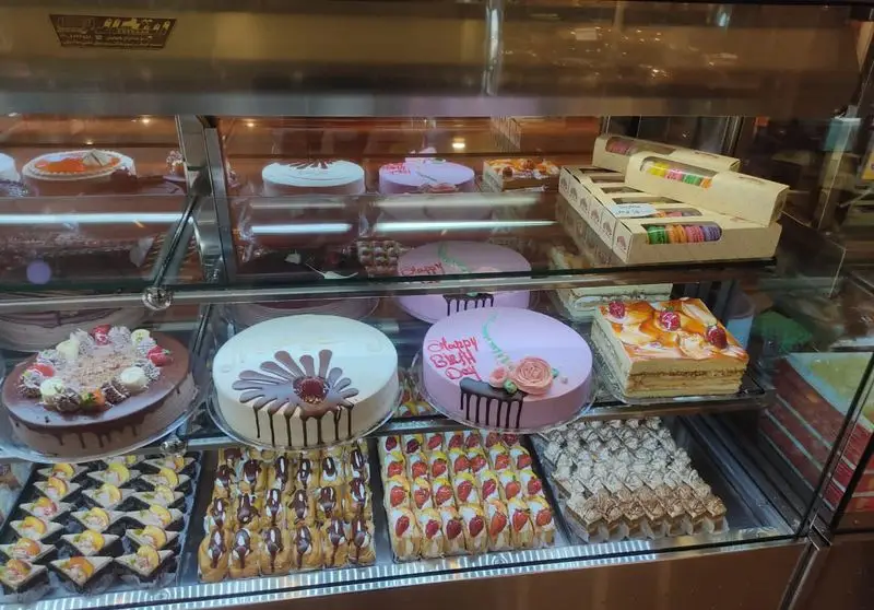 ویترین شیرینی سالوت تهرانپارس پر از انواع کیک تولد، دسرهای میوه‌ای و شیرینی‌های تازه و خوشمزه، آماده برای سفارش مشتریان.