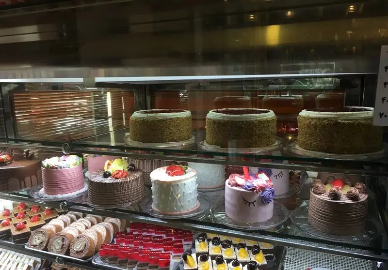 ویترین جذاب شیرینی سالوت تهرانپارس مملو از کیک‌های تولد متنوع، دسرهای رنگارنگ و شیرینی‌های تازه و اشتهاآور.