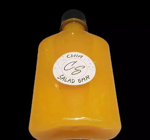 بطری نوشیدنی زرد رنگ CHIA SALAD BAR، حاوی دانه چیا، با لوگوی CS، محصولی سالم و رژیمی. مناسب برای سلامت و تغذیه.